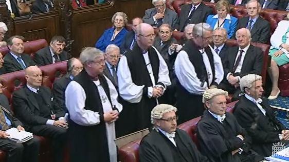 The Bishop of Rochester, with the Bishops of Norwich (l) and Leicester (r) proceed to the Bishops' Benches, pausing to face the Woolsack and bowing to the Cloth of Estate.