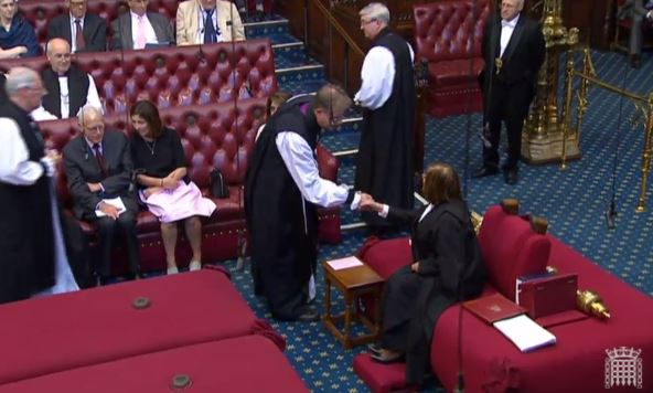 The Bishop of Oxford shakes hands with the Lord Speaker, before taking his seat on the Bishops' Benches